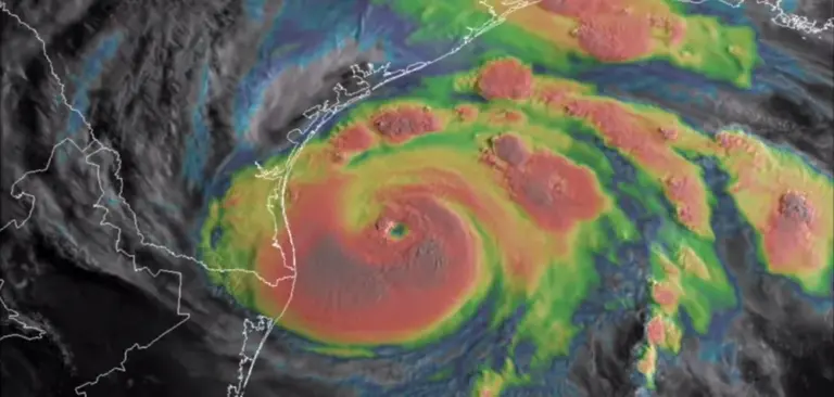 An infrared satellite image shows cold, high cloud tops in bright colors
