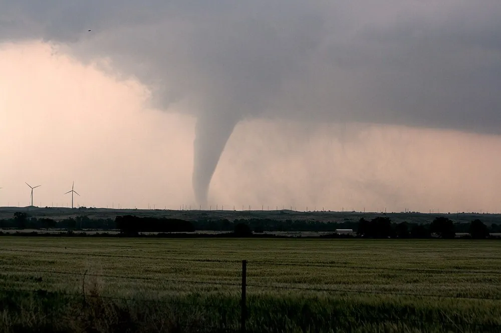 A tornado extending from the base of a thunderstorm to the ground